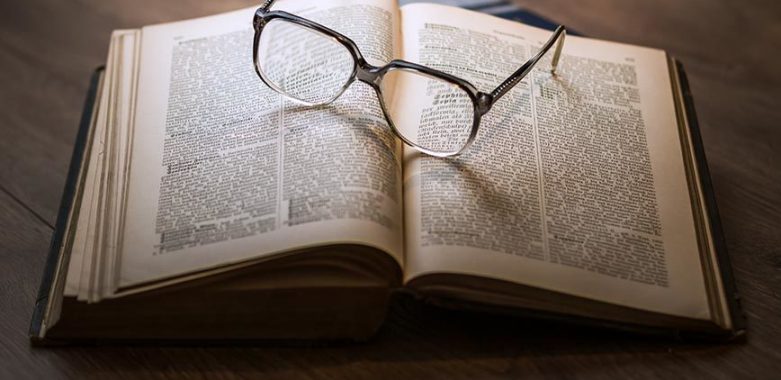 Blick auf aufgeschlagenes Buch mit Brille